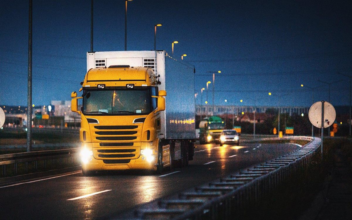 An articulated lorry running an overnight trunk route on a UK motorway at dusk